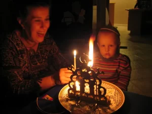 Hanukkah Halachot Sephardic grandmother and her grandson lighting Morocco hanukkah